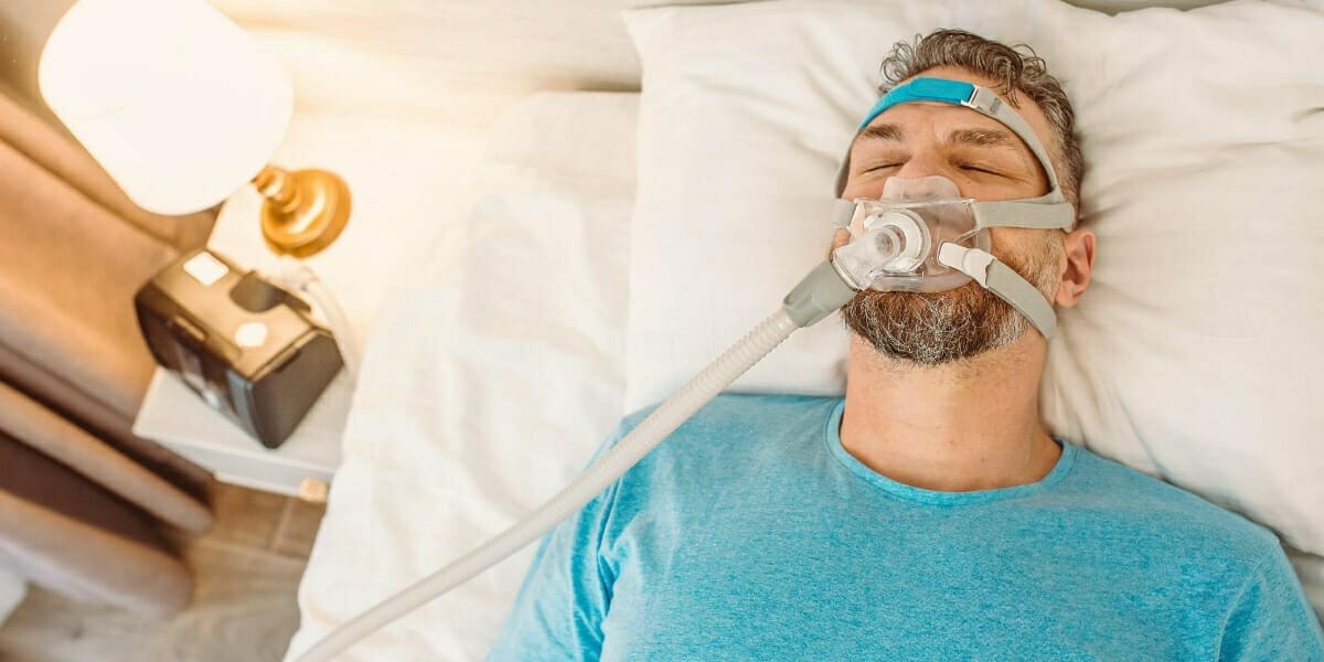 A CPAP machine complete with hose and mask.