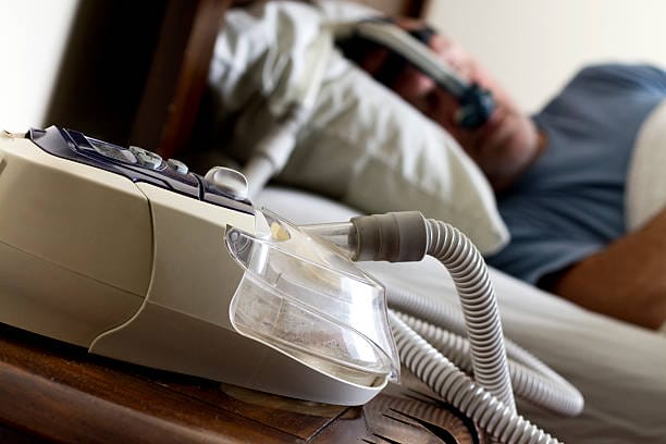Photo of a man sleeping while wearing a CPAP mask.